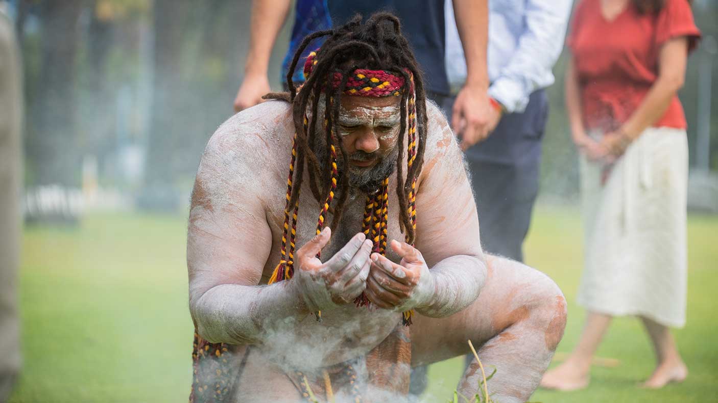 An Aboriginal dance interacting with smoke at the cleansing ceremony