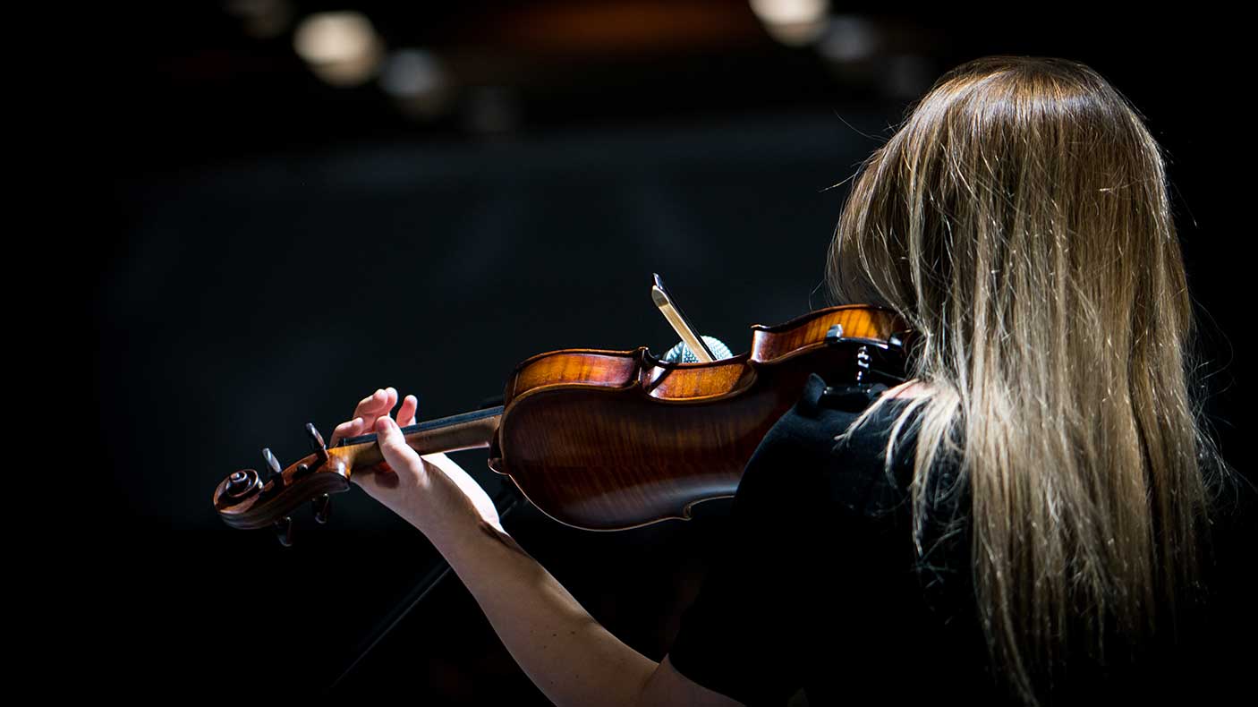 Girl playing the violin in concert hall