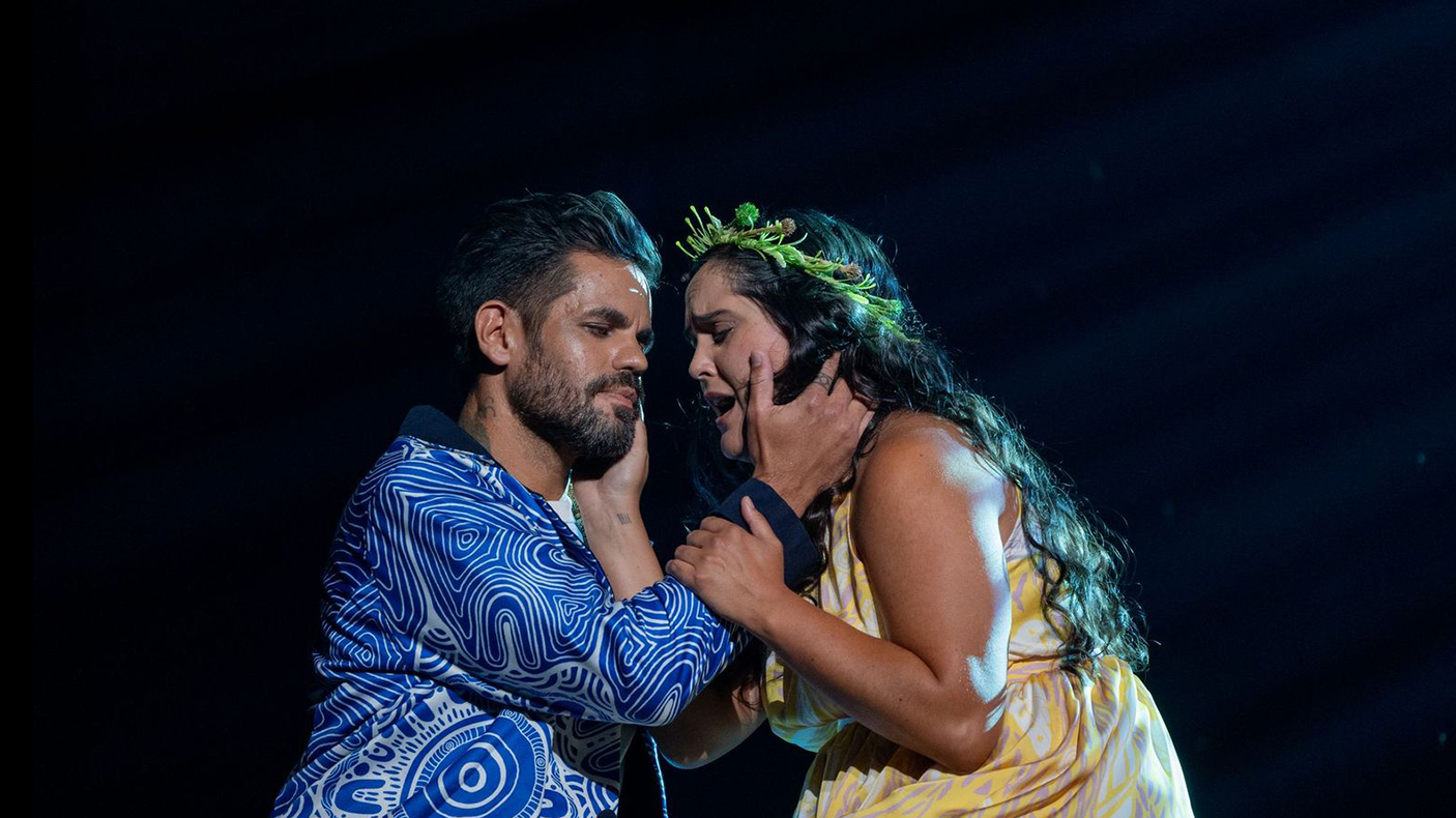 Two performers embrace as part of a live performance