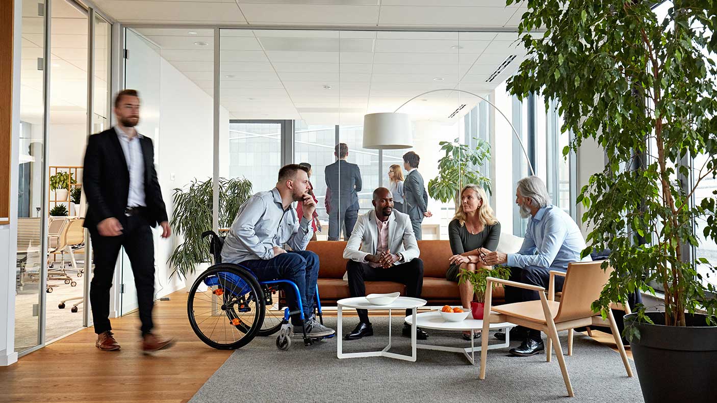 A group of people sitting and talking in an office environment
