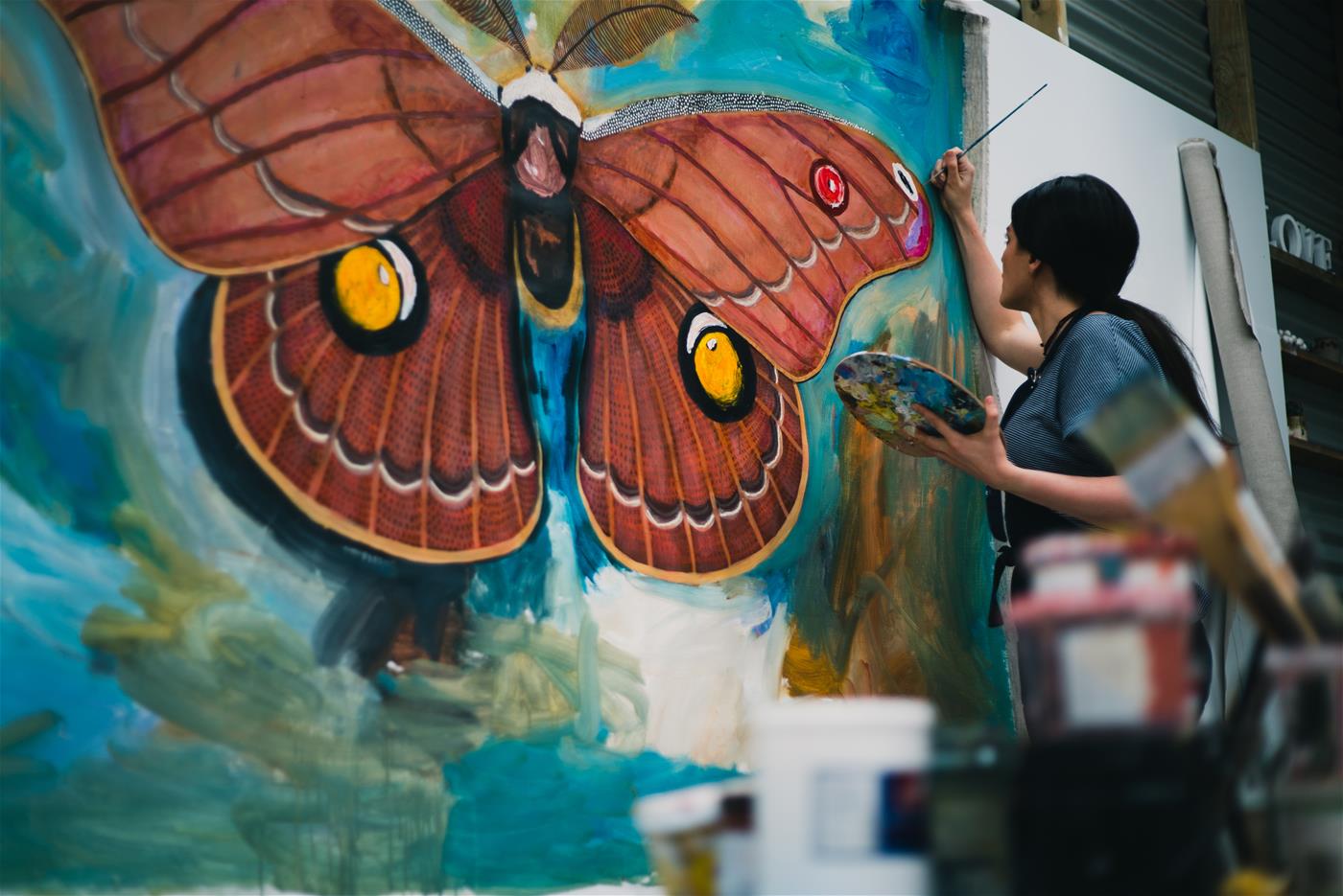 Albany Artist and Creative Grid Mentee Chelsea Hopkins-Allan painting a larger than life Helena Gum Moth.