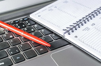 High angle view of diary and pen on a computer keyboard