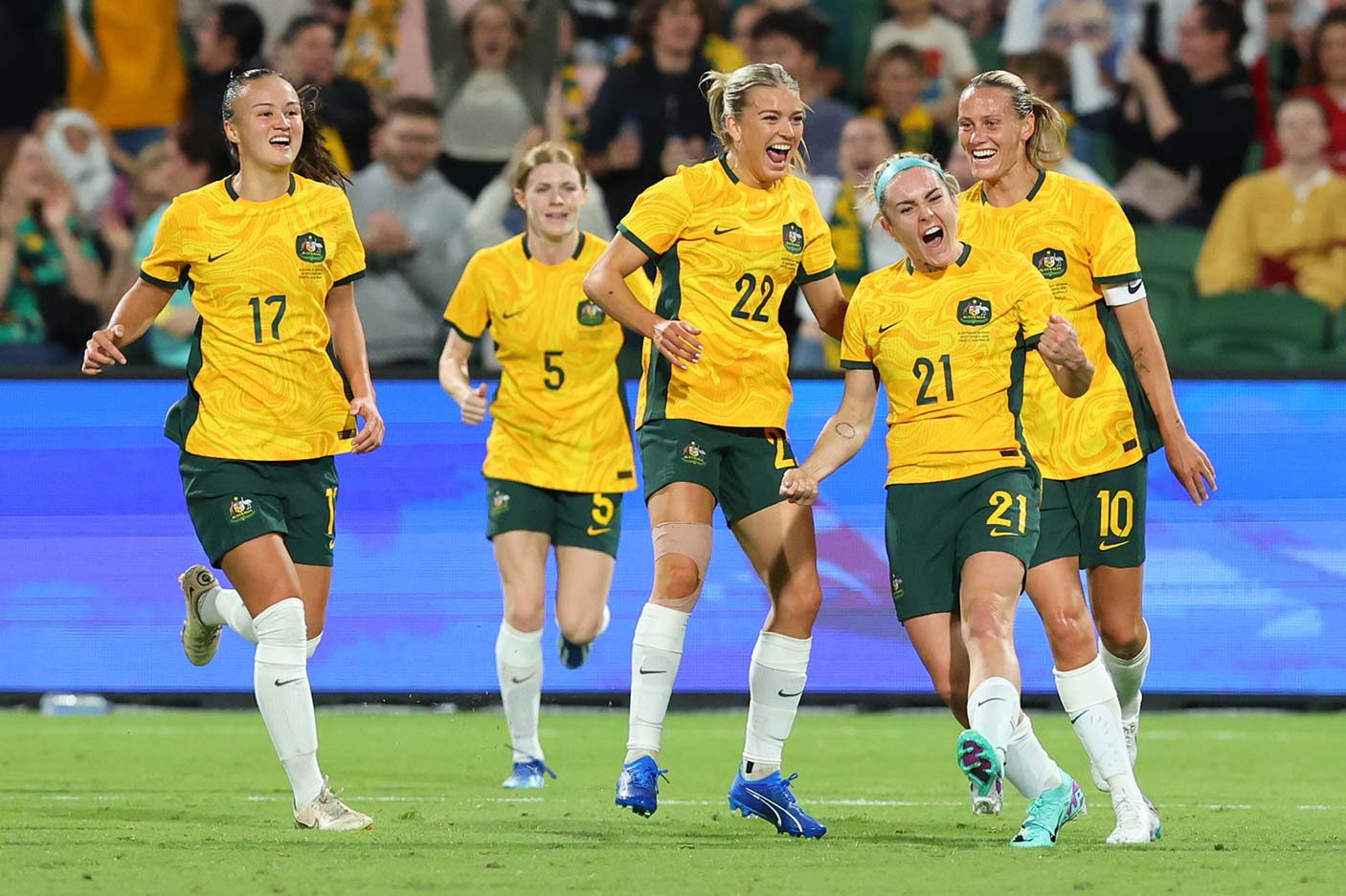 Matildas' players celebrating after a goal at a football match
