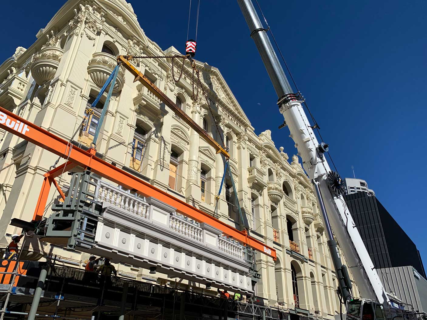 A crane lifting a restored balcony on His Majesty's Theatre