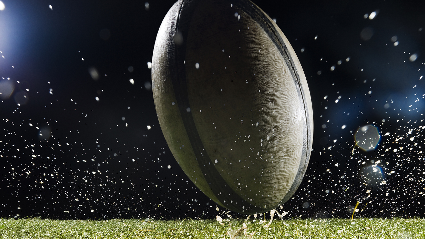 A close up photo of a rugby ball with water droplets