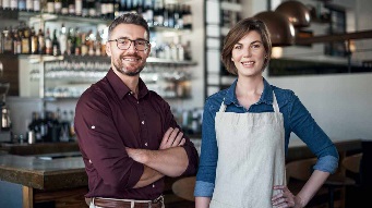 Cropped portrait of two businesspeople standing proudly in their coffee shop