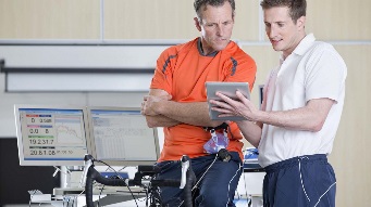 A sports scientist showing an athlete some results on a tablet