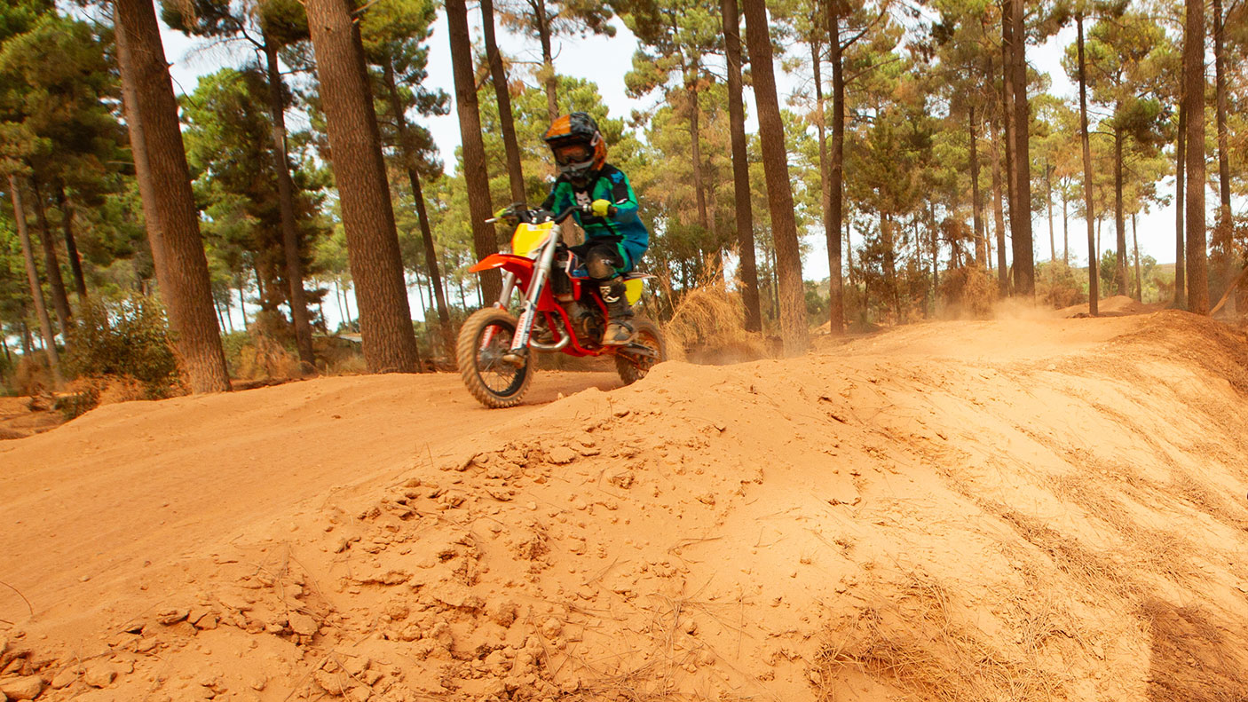 Child riding a small off road motor bike on a gravel track.