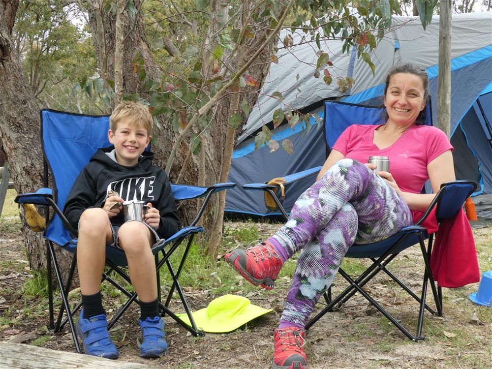A mother and child sitting in camping chairs