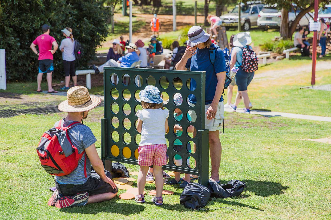 A family playing a giant game of Connect 4 on the grass