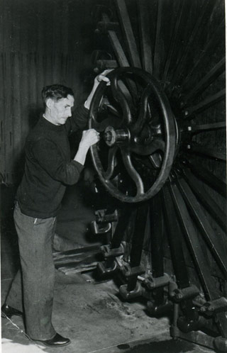 A historic photo of a man opening the fumigator