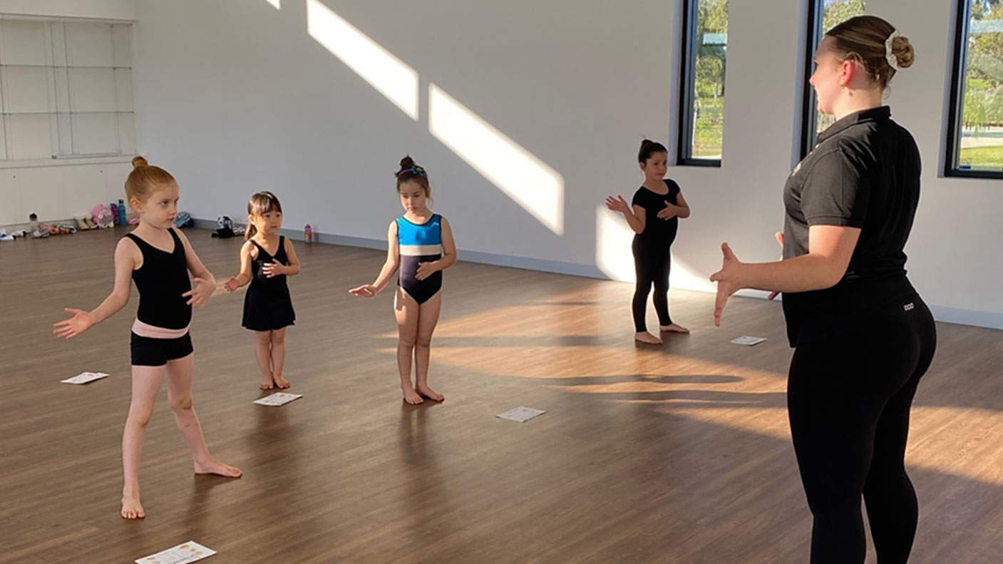 Calisthenics coach, Sidney North instructs her young students in a dance studio.