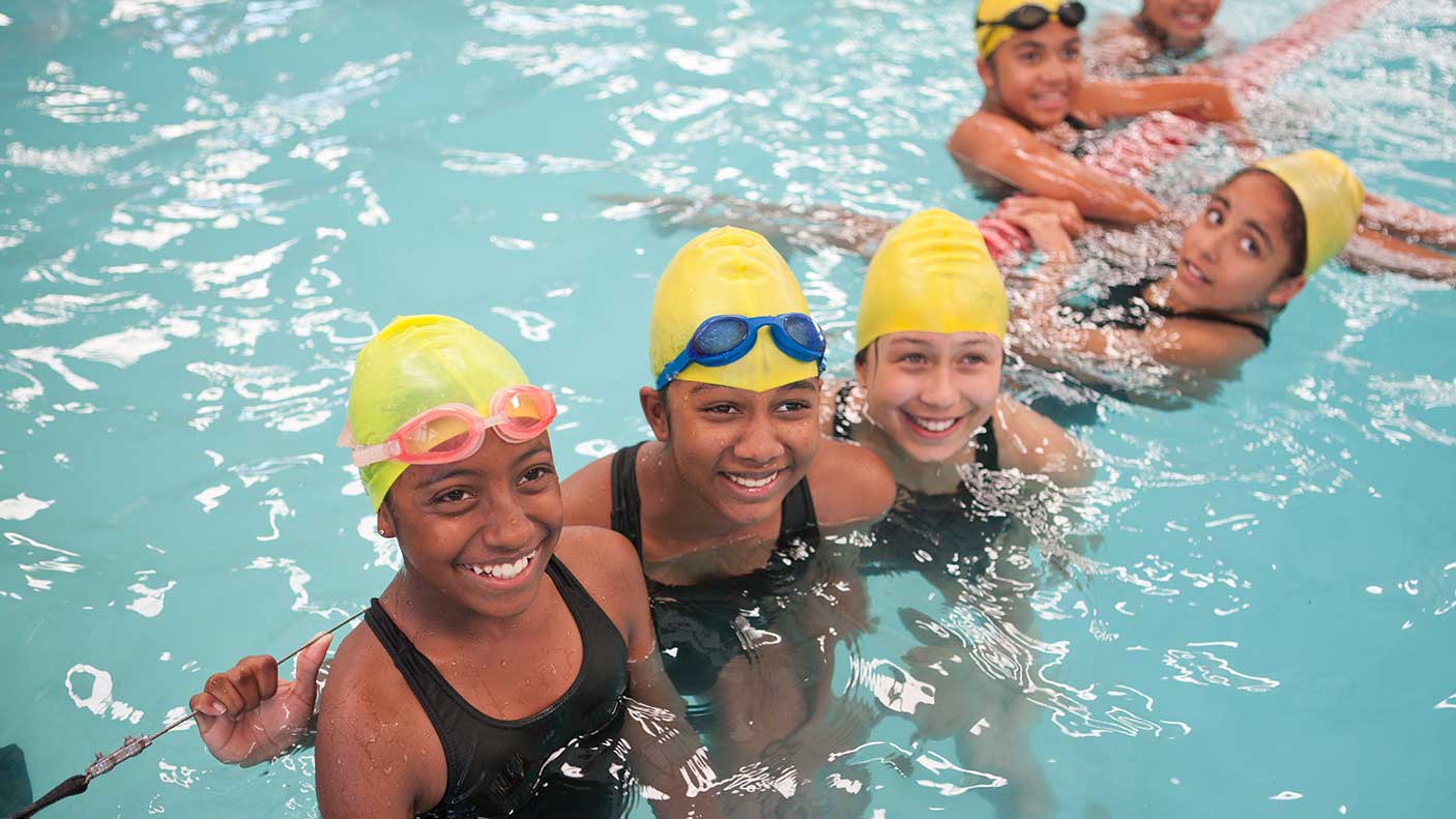 A group of girls in a pool during a swimming lesson