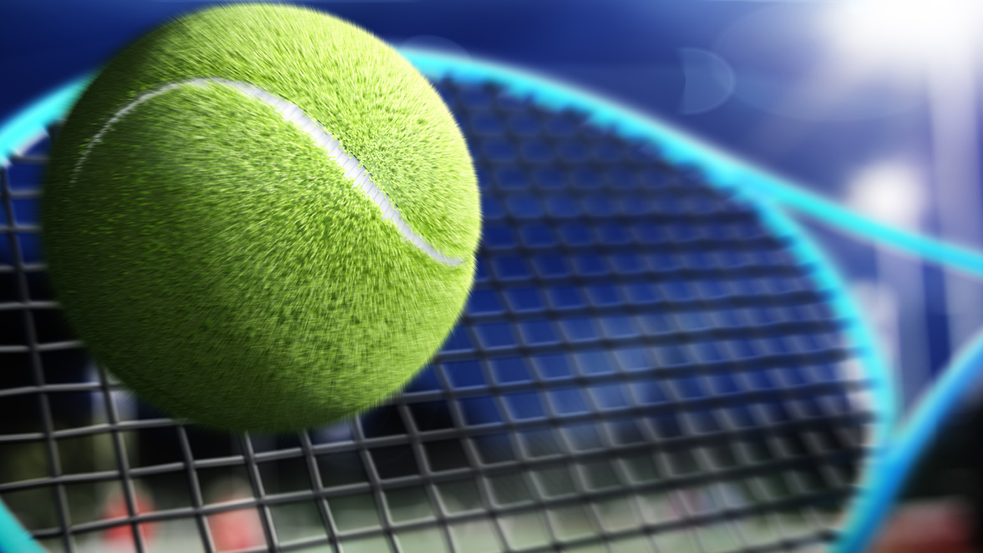 close up of a tennis ball making contact with a tennis raccquet